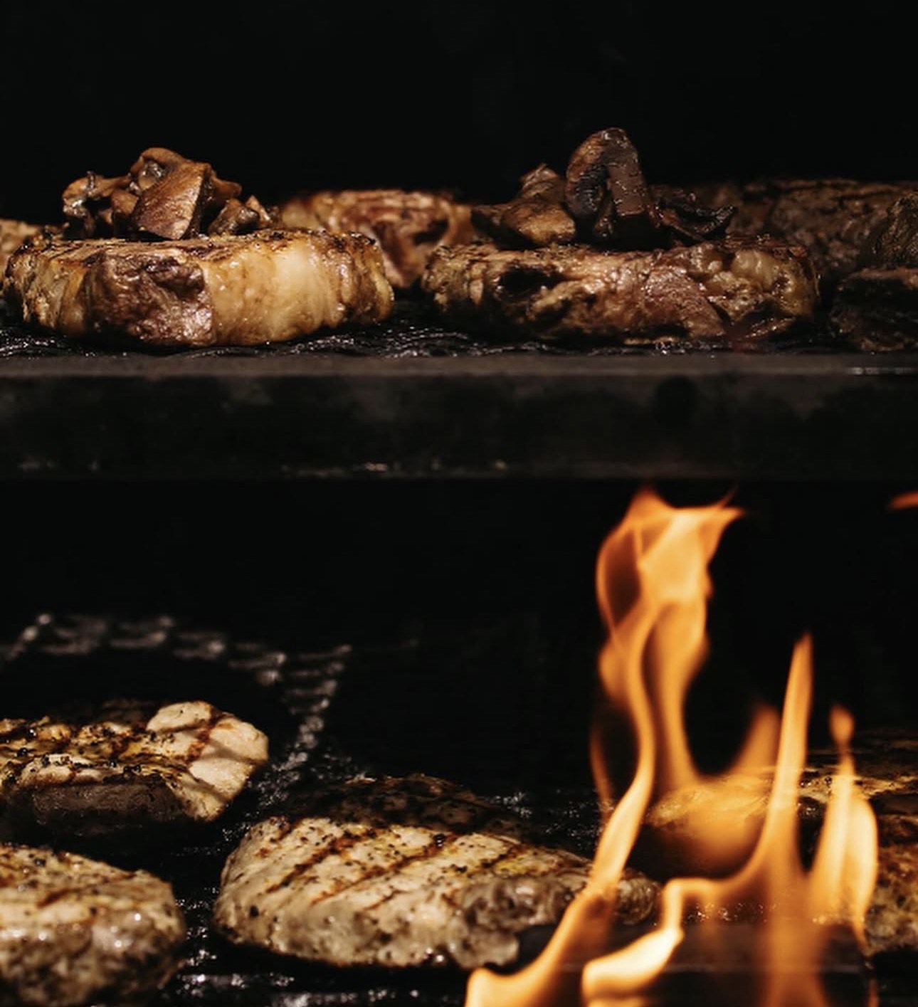 Steaks on two-rack grill with flame