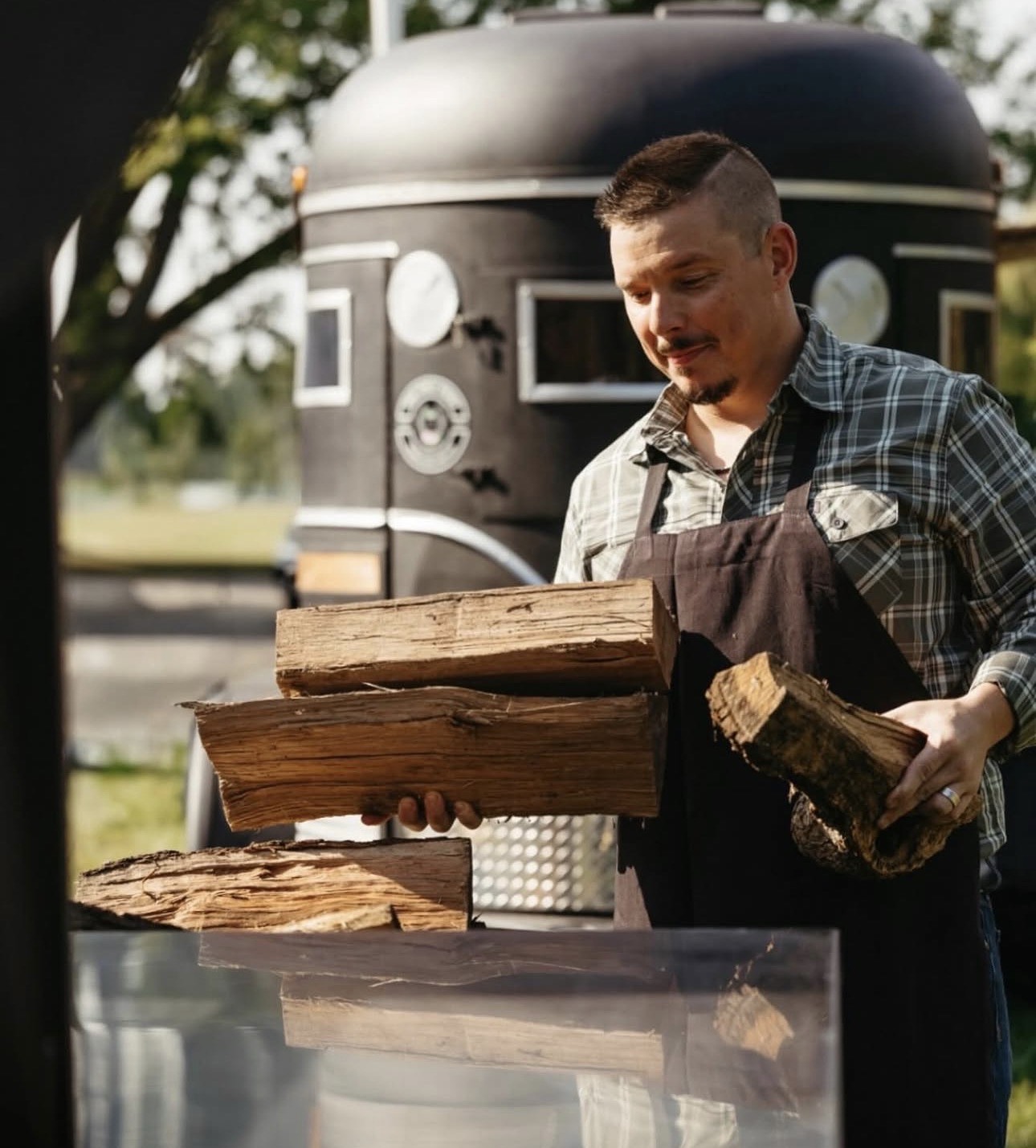 Grill master loading the wood smoker